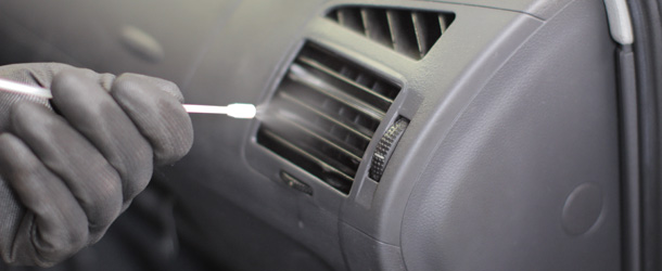 Automonteur reinigt het airconditioningsysteem met behulp van een spuitbus